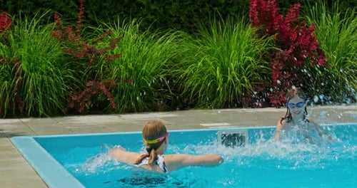 Two Teenage Girls Joyfully Splashing Water in a Pool Slowmotion Video Captures Their Playful Fun