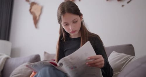Teen Girl Reads and Writes in a Magazine