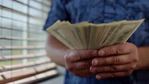 Man Counting US Currency Money Indoors