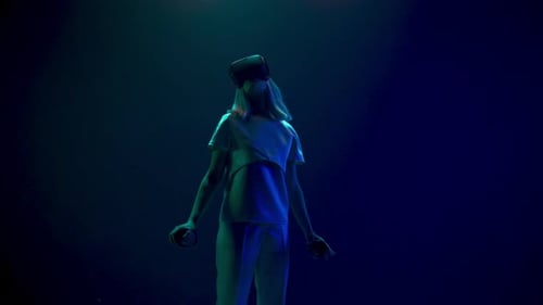 Woman Experiences Virtual Reality with Headset and Controllers