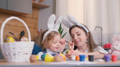 Mother and Daughter Draw Easter Eggs in the Kitchen Room