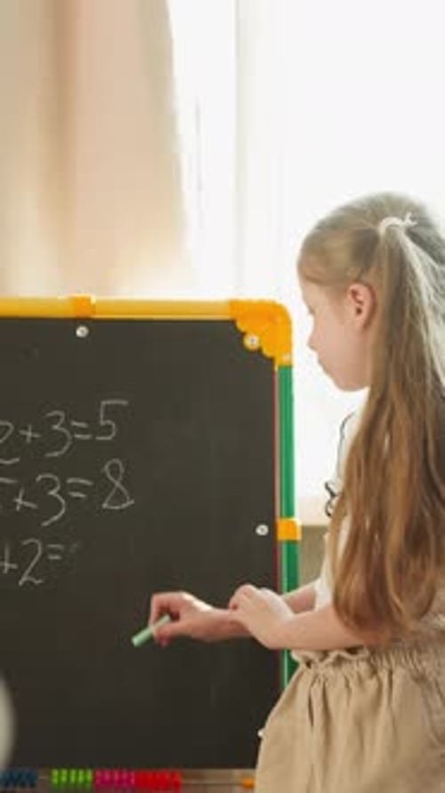 Child Writes Math on Chalkboard at Home