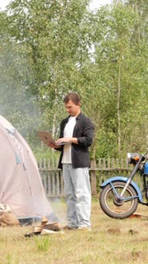 Man Camping, Works on Laptop, Rural Setting