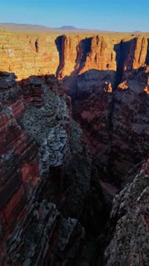 Drone footage among the layered geological formations in the deep canyon.