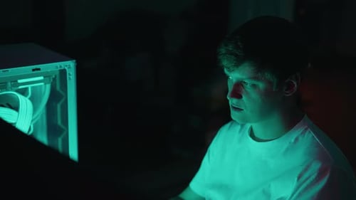 Closeup Face of Programmer Male Illuminated By Glow of Computer Screen and Custom Pc Focused