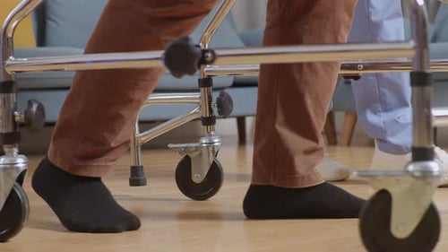 Older Adult Using Walker with Healthcare Assistant