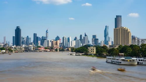 Time-lapse of ferries moving on the Chao Phraya river, Bangkok skyline background