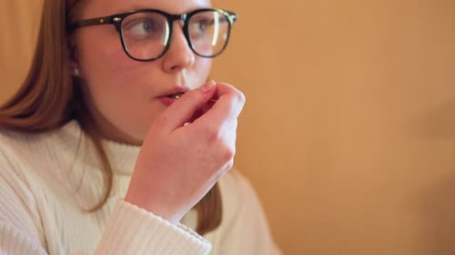 Young Adult Enjoys Cake Bite with Fork Indoors