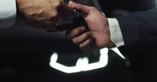 Two Male Hands Exchanging a Car Key