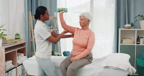 Therapist Helping Senior Woman Lift Weights