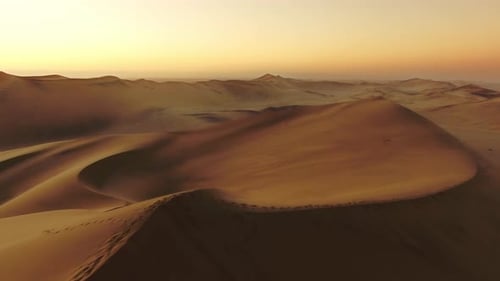 4k aerial drone footage of a solitary man walking along Dune 7 in the Namibian Desert