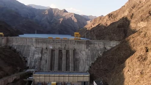 Aerial view of hydroelectric power station surrounded with mountains