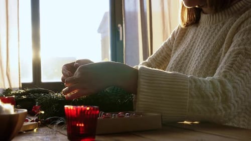 Woman Making Holiday Wreath with Glue Gun Indoors