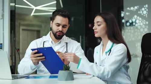 Doctors Discussing Medical Records in Modern Office