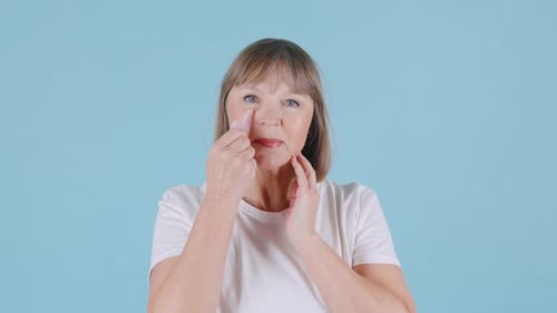 Woman Massaging Face with Gua Sha Tool