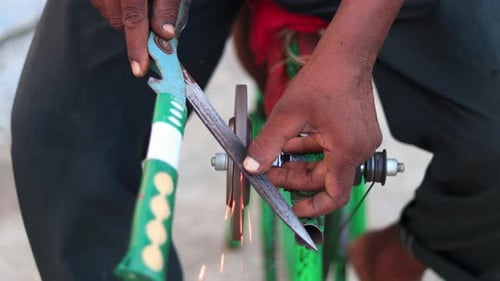 Top view of a man sharpening gardening scissors on a makeshift mobile sharpening machine on a manual