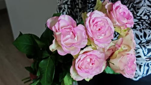 Handaufnahme einer Frau mit rosa Rosen