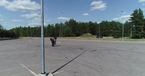 Motorcycle Stunt Rider on Paved Lot During Daytime