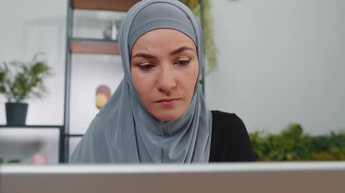 Muslim Businesswoman Freelancer at Office Workplace Working on Laptop Computer Sends Online Messages