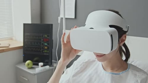Woman Uses VR Headset in Hospital Bed