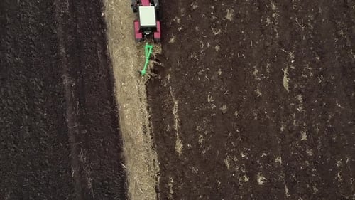 Red tractor plowing the field in Ukraine