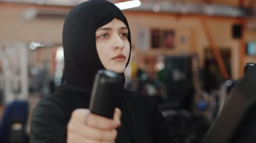 Woman Using Cross Trainer in Gym for Cardio Workout