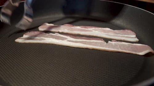 Static Close Up Shot of Sliced Bacon Cooking in a pan