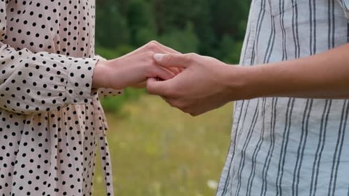 Man and Woman Holding By Hands Outdoors Young Couple Standing Together in the Field
