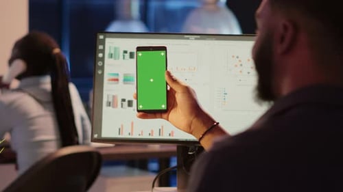 Man Holding Green Screen Phone in Office