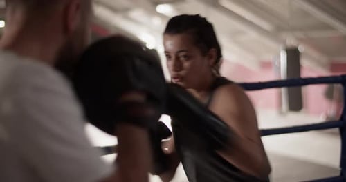Woman Boxing with Trainer in Indoor Gymnasium