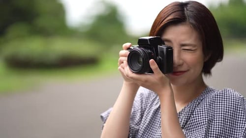 Woman Smiling with Camera in Green Setting