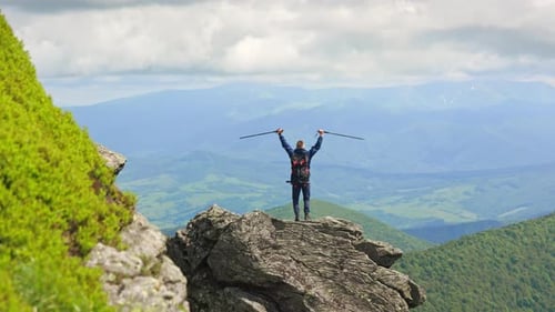 Male Tourist Wearing Backpack Standing on Rock Hill
