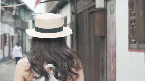 Young Woman Walks Down Street Taking Pictures