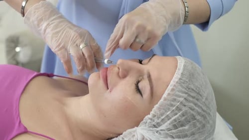 Clip Shows Intensive Facial Skin Care in a Beauty Clinic a Doctor Injects Filler Into the Patient's