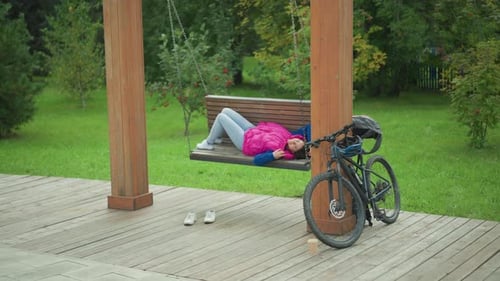 Woman Relaxing on Swing in the Park