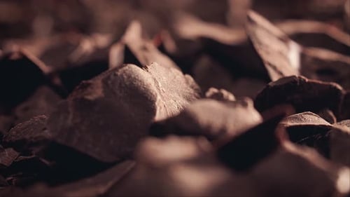 Chunks of sweet dark sliding backdrop, close-up. Gourmet dessert ingredient.