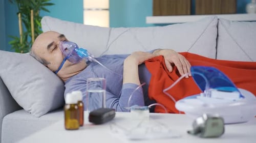Patient pulmonaire, homme qui tousse et porte un respirateur.