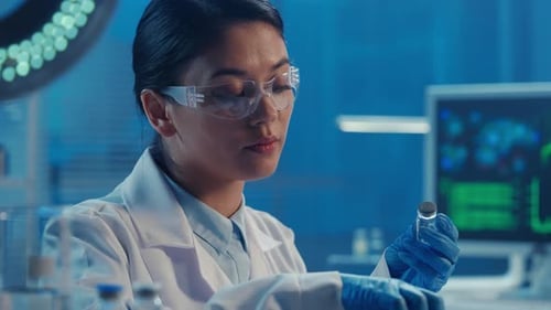Woman Scientist Draws Fluid From Vial into Syringe