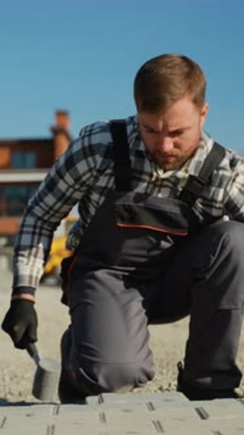 Construction Worker Installing Blocks Outdoors During the Day