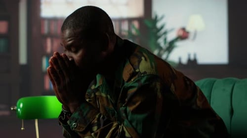 Distraught Man in Camouflage Sits with Worry