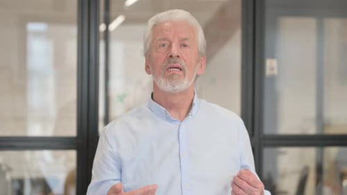 Blogging Senior Old Businessman Doing Video Chat in Office