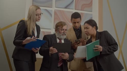 Business People Meeting and Looking at Tablet