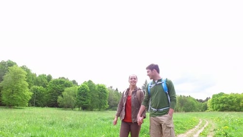 Happy Couple Hiking and Holding Hands in Nature