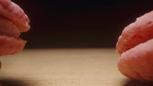 pink round cookies that look like macaron, the camera slides through them on the table and they go i