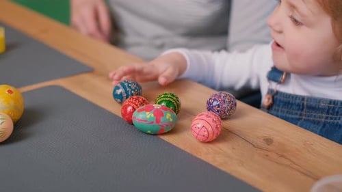 Grandmother and Granddaughter Paint Eggs for Easter They are Dressed in Bunny Ears