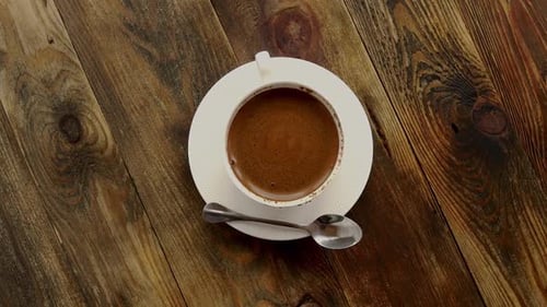 Steaming Cup of Coffee on Rustic Table