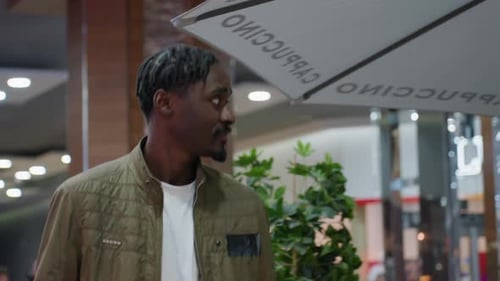 Young Man Smiling Walking Inside Shopping Mall
