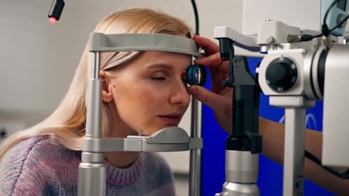 Nahaufnahme in einer Augenklinik diagnostiziert ein junger Arzt die Augen eines jungen Mädchens mit einem