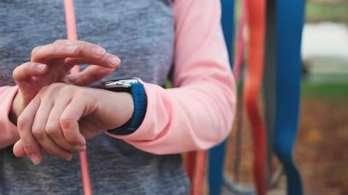 Woman Using Smart Watch in an Urban Park