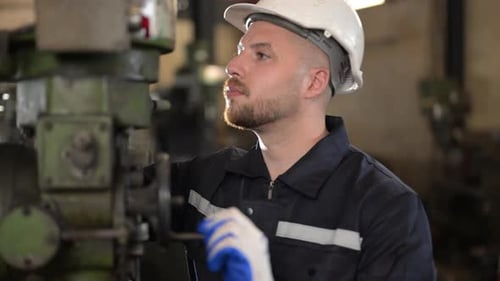 Male Mechanical Engineer Repairing Engine Machine at Factory